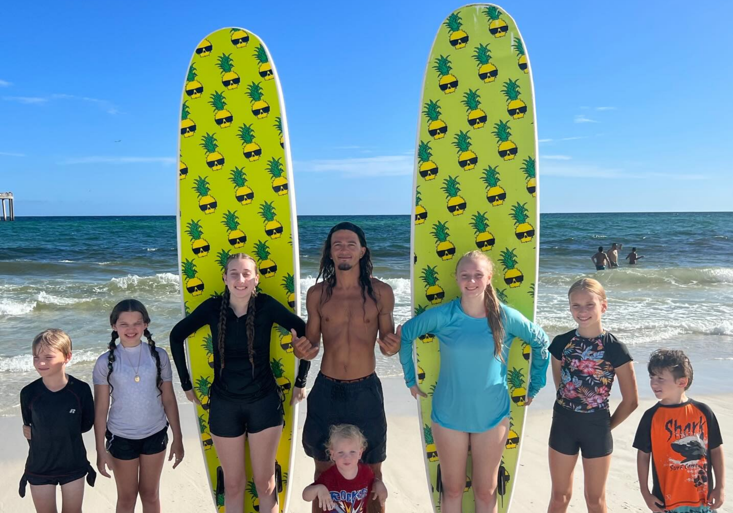 Group surf lesson in Destin Florida with instructor and beginner surfers on boards