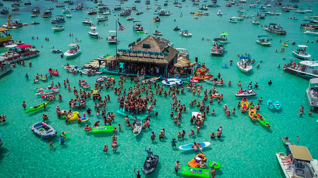 Crowds of boats and people gathered at Crab Island in Destin, Florida enjoying emerald water activities on the Emerald Coast.