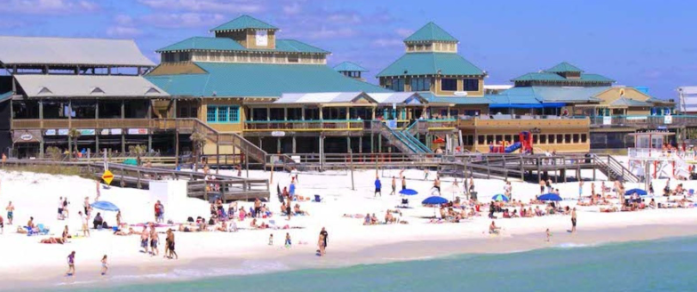Okaloosa Island Boardwalk with beachfront restaurants and visitors enjoying the beach in Fort Walton Beach, Florida