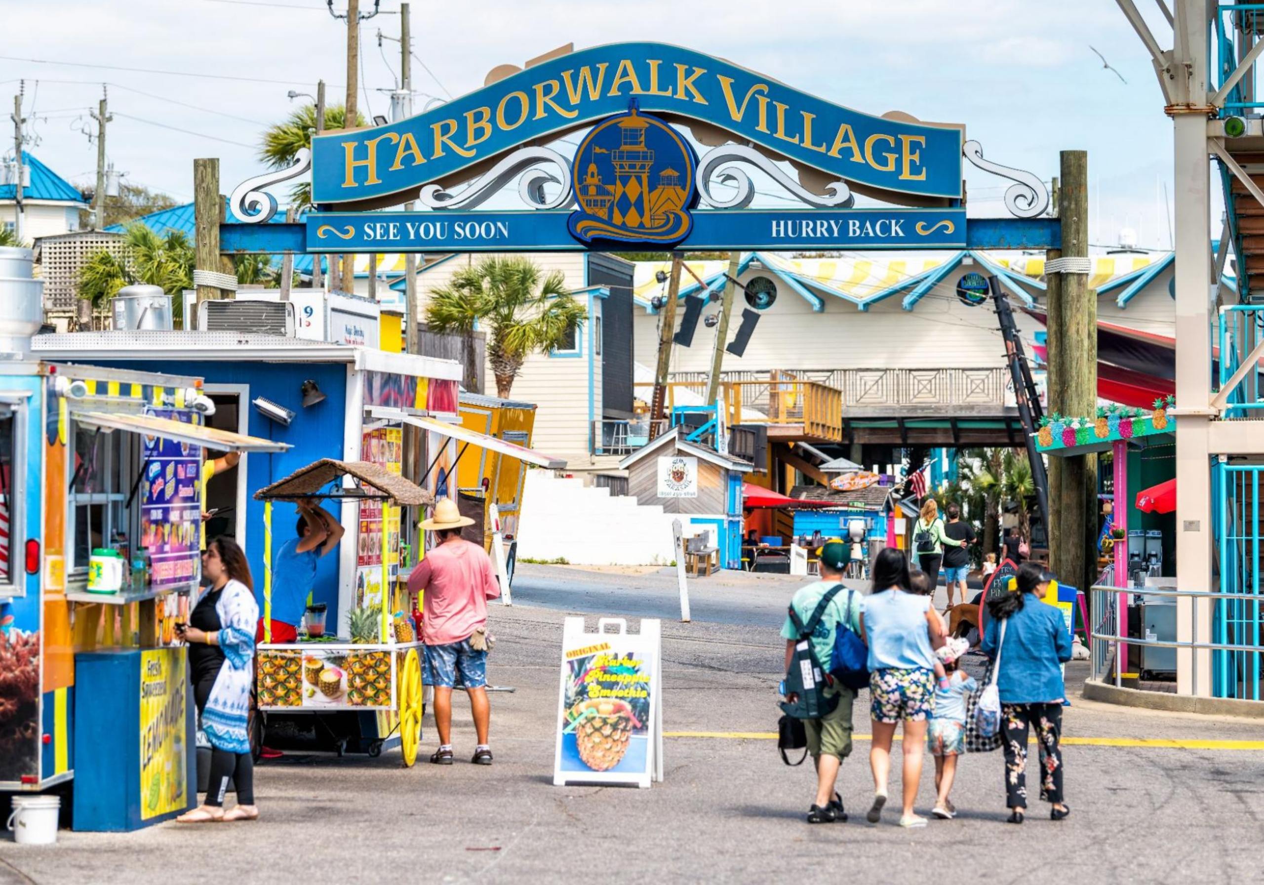 HarborWalk Village entrance in Destin with shops, restaurants, and colorful signage