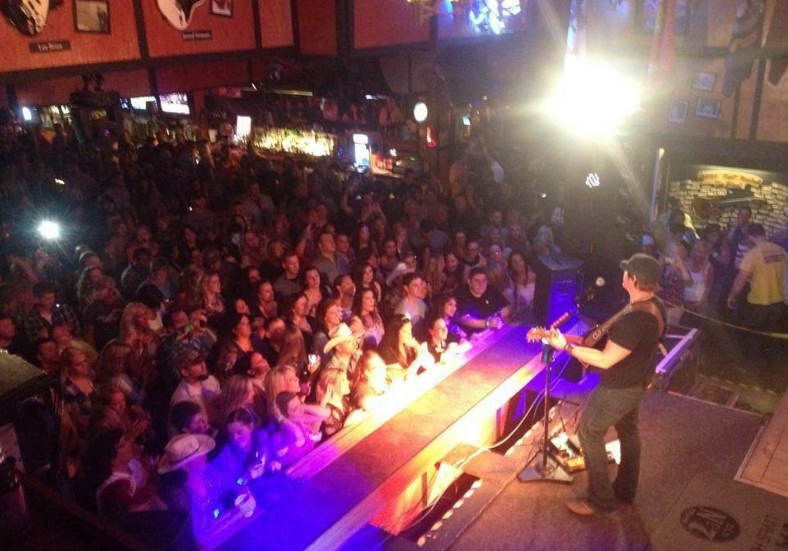 Live concert crowd at The Block in Fort Walton Beach with stage lights and nightlife atmosphere