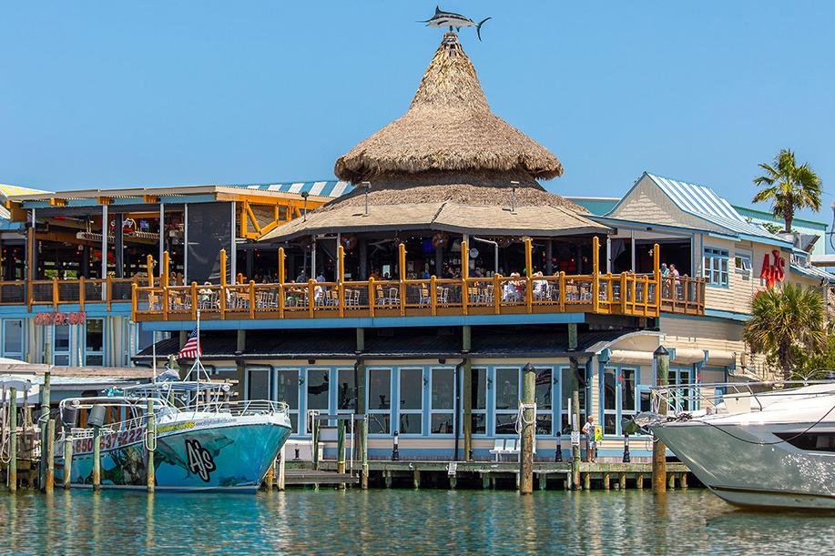 AJ’s Seafood and Oyster Bar on Destin Harbor with waterfront views and boats along the boardwalk