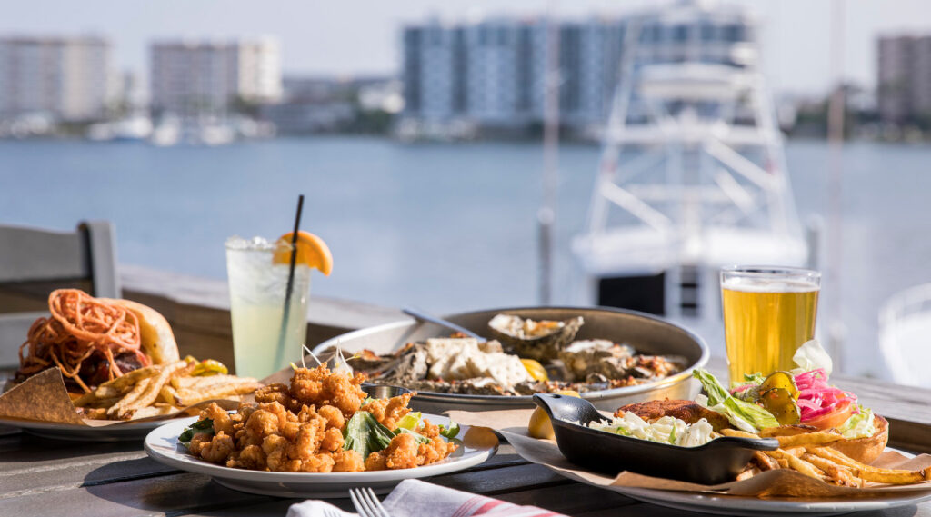 Fresh seafood platter with shrimp, oysters, and drinks at a waterfront restaurant near Destin, Florida