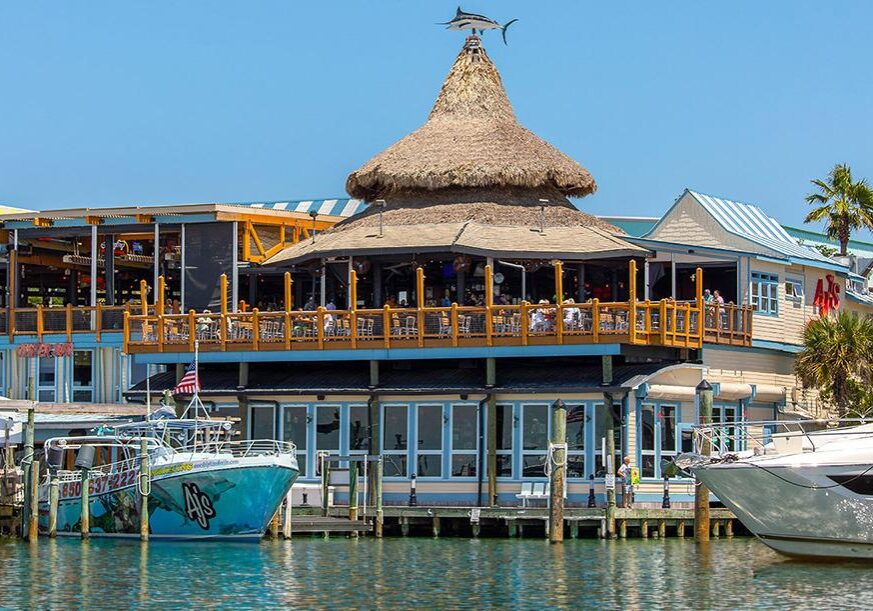 AJ’s Seafood and Oyster Bar on Destin Harbor with waterfront views and boats along the boardwalk