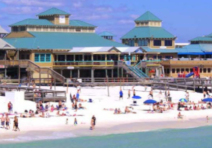 Okaloosa Island Boardwalk with beachfront restaurants and visitors enjoying the beach in Fort Walton Beach, Florida